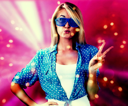 Young woman wearing shutter shades sunglasses on a pink background