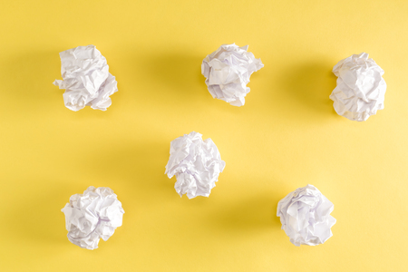 Crumpled paper balls on a yellow backgroundの写真素材