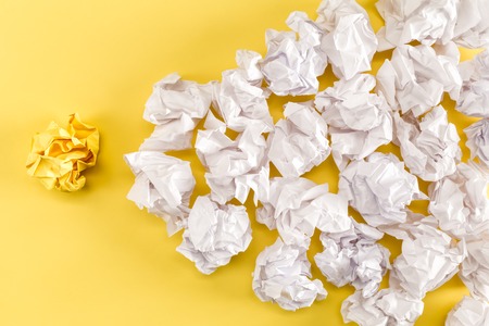 Crumpled paper balls on a yellow backgroundの写真素材
