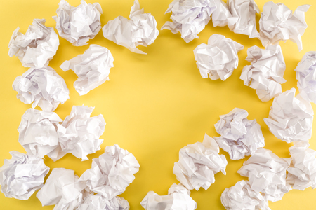 Crumpled paper balls on a yellow backgroundの写真素材