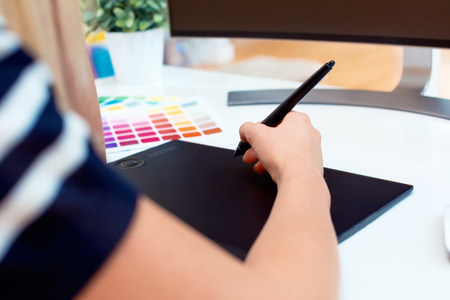 Graphic designer using her graphic tablet in an officeの写真素材