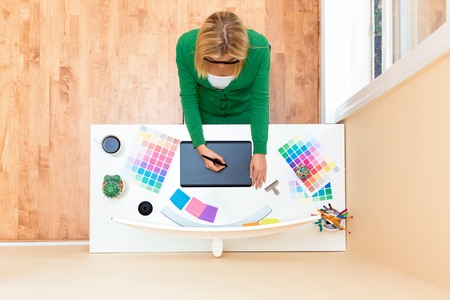 Graphic designer using her graphic tablet in an officeの写真素材