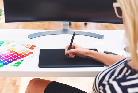 Graphic designer using her graphic tablet in an officeの写真素材