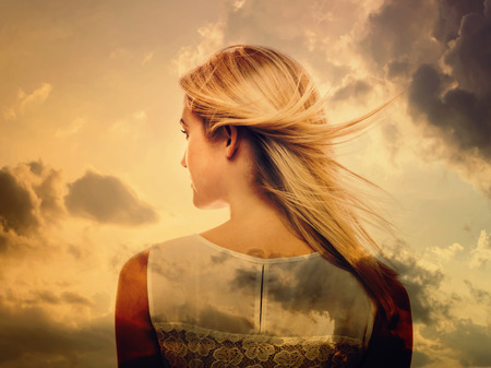 Double exposure of beautiful young woman and the skyの写真素材