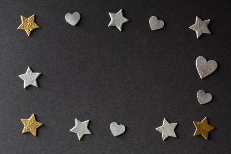 Small hearts and stars on black paper backgroundの写真素材