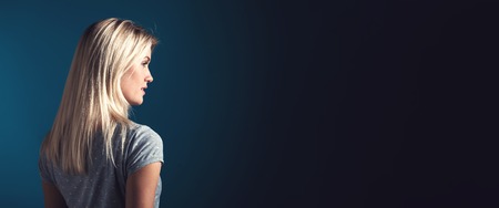 Happy young woman on a dark blue backgroundの写真素材