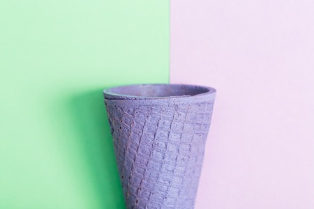 Purple painted ice cream cone on a pastel pink and green backgroundの写真素材