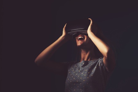 Happy young woman using a virtual reality headsetの写真素材