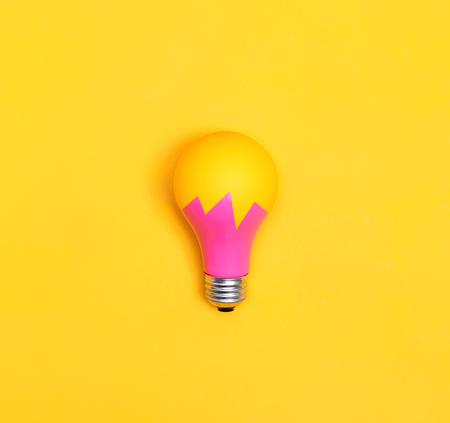 Colored light bulb on vivid colored backgroundの写真素材