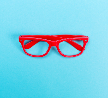 Glasses on a vivid blue paper background