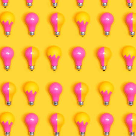Colored light bulbs aligned on a yellow background