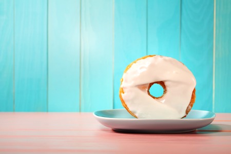 Donut and dish on a pastel blue and pink backgroundの写真素材