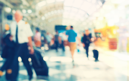 Defocused airport corridor with walking travelersの写真素材