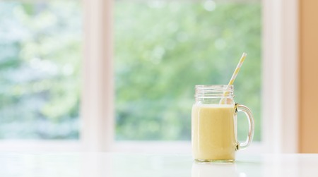 Mango smoothie beverage in a bright roomの写真素材