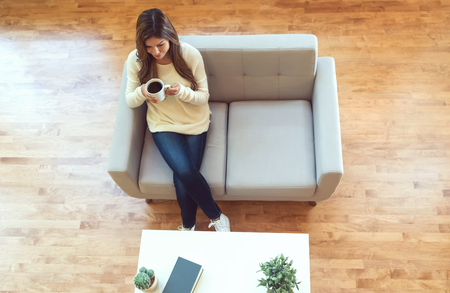 Young hispanic woman drinking coffee at homeの写真素材