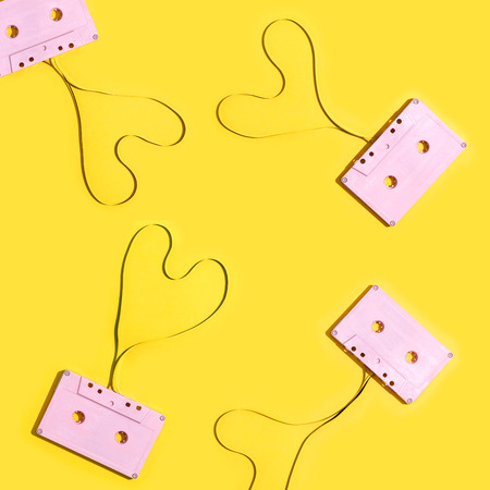 Series of pink cassette tapes on a yellow backgroundの写真素材