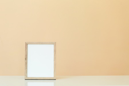 Blank picture frame on a muted yellow backgroundの写真素材