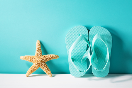 Summer theme with sandals and starfish on a bright blue backgroundの写真素材