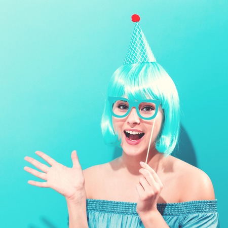 Party theme with a woman in a bright blue wigの写真素材