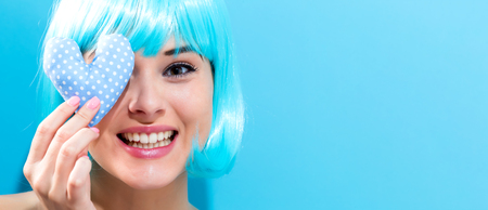 Beautiful woman in a bright blue wig with heartsの写真素材