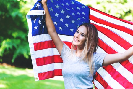 GIrl with an American flag on the fourth of July in her backyardの写真素材
