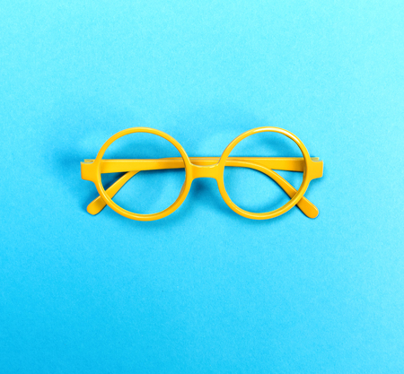 A pair of round glasses on a bright blue backgroundの写真素材