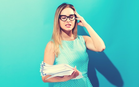 Stressed office woman in glasses with a stack of documents