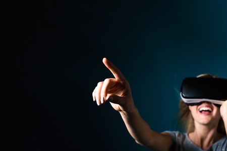 Happy young woman using a virtual reality headsetの写真素材