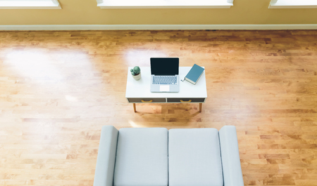 Overhead view of a home interior with gray loveseat and laptopの写真素材