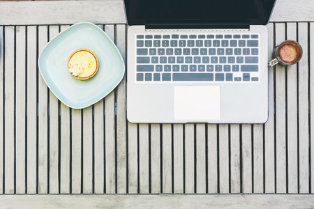 Overhead view of laptop and desserts outside