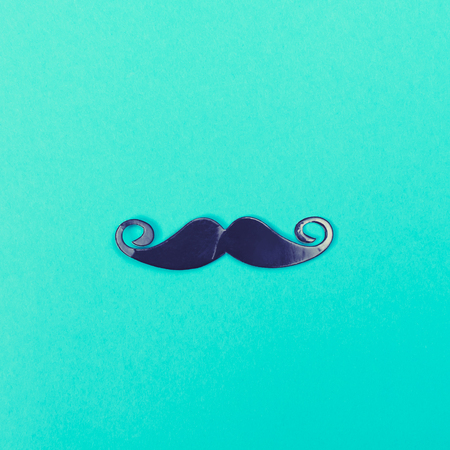 Paper party mustache accessory on a bright blue backgroundの写真素材