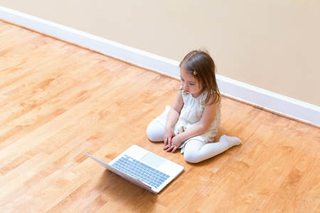 Little girl with her laptop computer at homeの写真素材