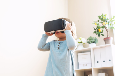 Toddler girl using a virtual reality headset in her houseの写真素材