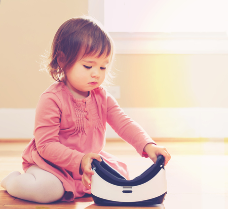 Toddler girl using a virtual reality headset in her houseの写真素材