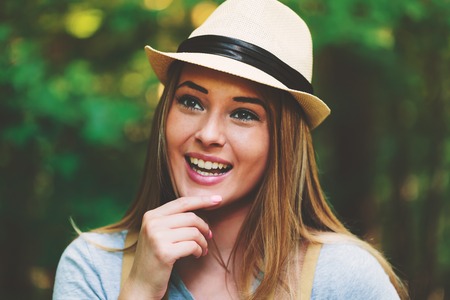 Portrait of a woman in the forest with a backpack and hatの写真素材