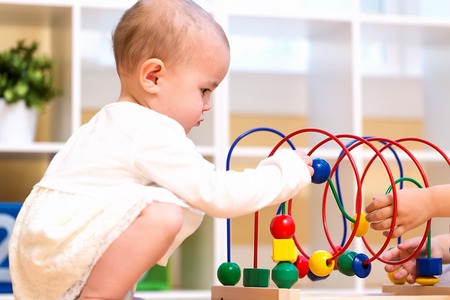 Toddler girl playing with toys in her houseの写真素材