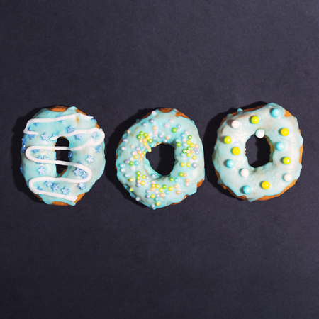 Colorful glazed donuts on a chalky black backgroundの写真素材