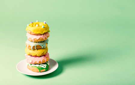 Colorful glazed donuts on a bright green backgroundの写真素材
