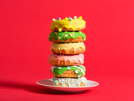 Colorful glazed donuts on a bright red backgroundの写真素材