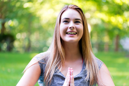 Young woman meditating outside on a beautiful summer dayの写真素材