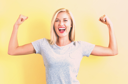 Powerful young woman on a yellow backgroundの写真素材