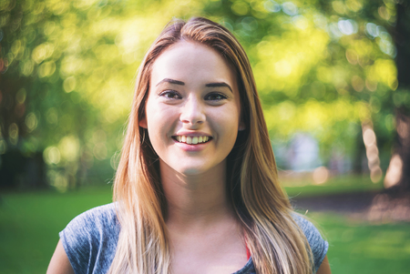 Portrait of a happy young woman outside on a bright summer dayの写真素材
