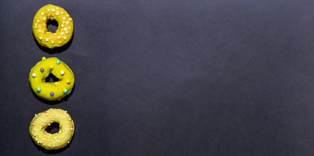 Colorful glazed donuts on a chalky black backgroundの写真素材