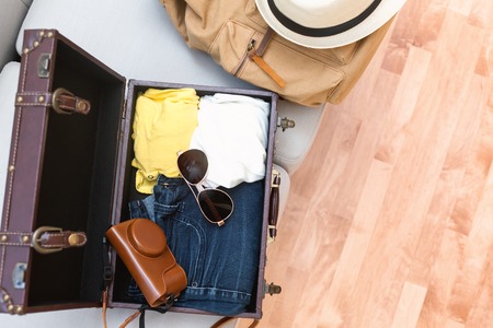 Packing a suitcase and backpack for a tripの写真素材