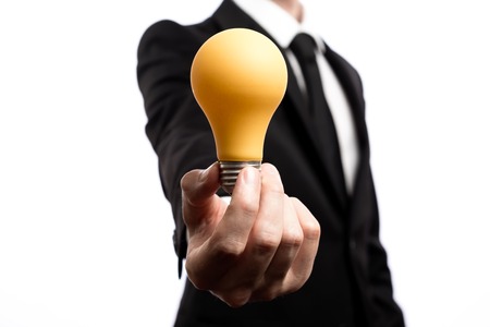 Businessman showing a lightbulb, inspiration concept, on a white backroundの写真素材