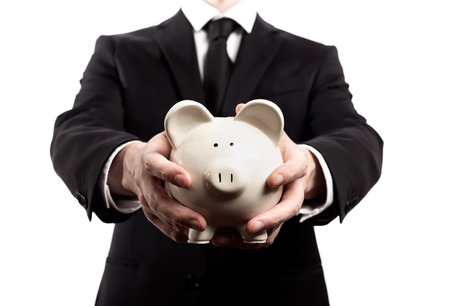 Businessman holding a piggy bank on a white backgroundの写真素材