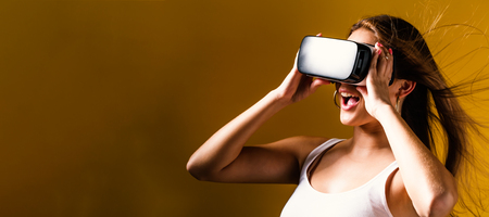 Happy young woman using a virtual reality headsetの写真素材