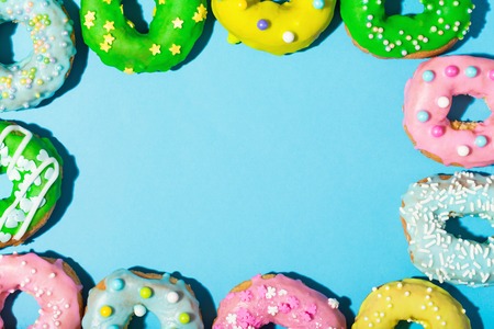Colorful glazed donuts on a bright blue backgroundの写真素材