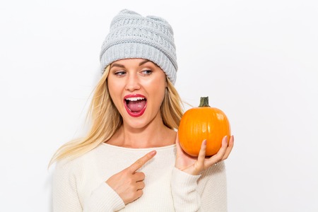 Young blonde woman holding pumpkins for halloweenの写真素材