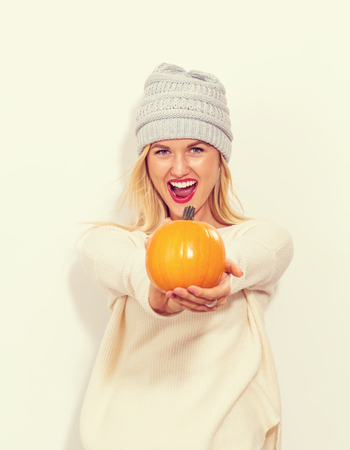Young blonde woman holding pumpkins for halloweenの写真素材